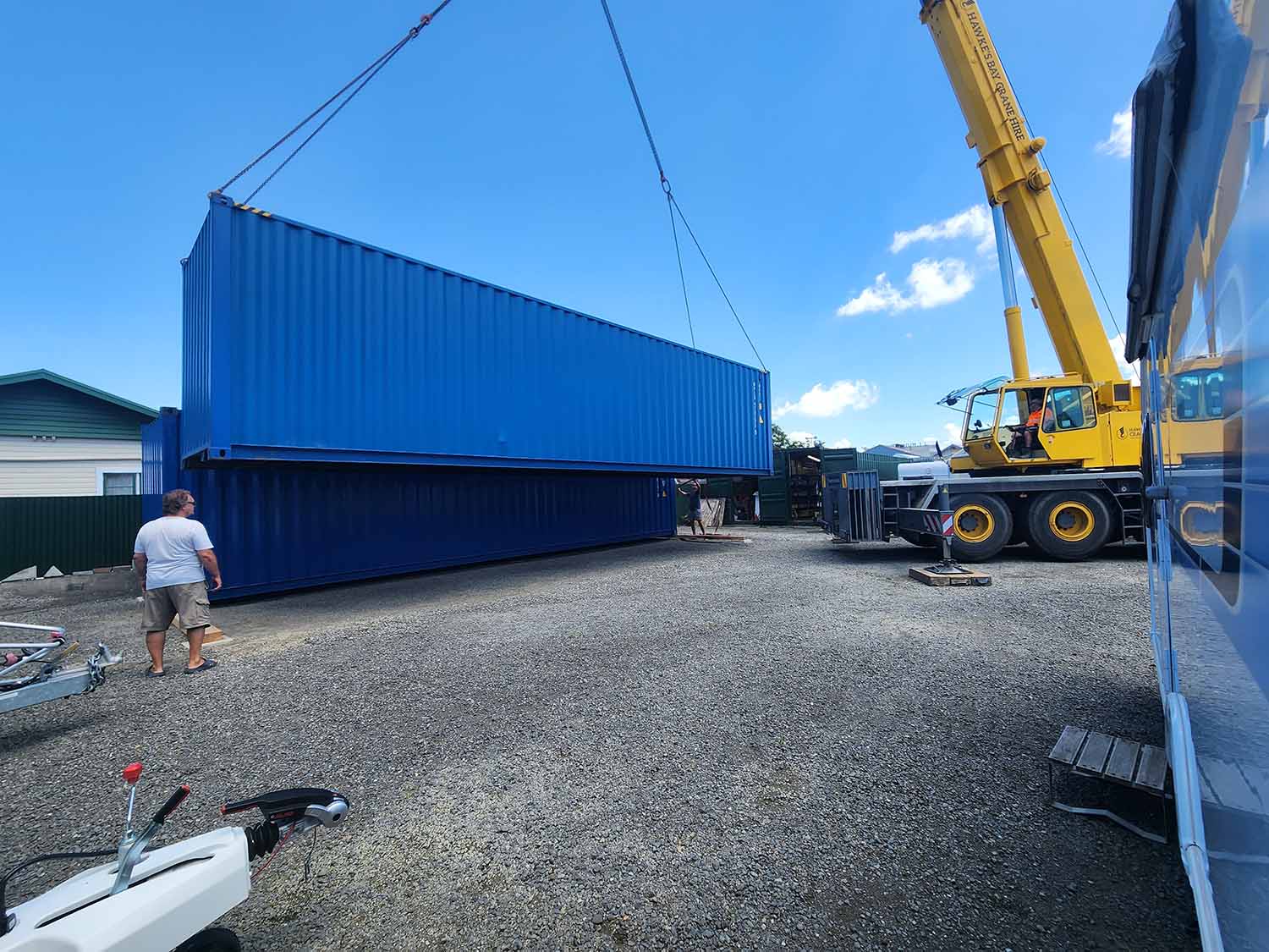 Blue containers being brought in by crane to set up the Smile Caravans property for their business in Hawkes Bay
