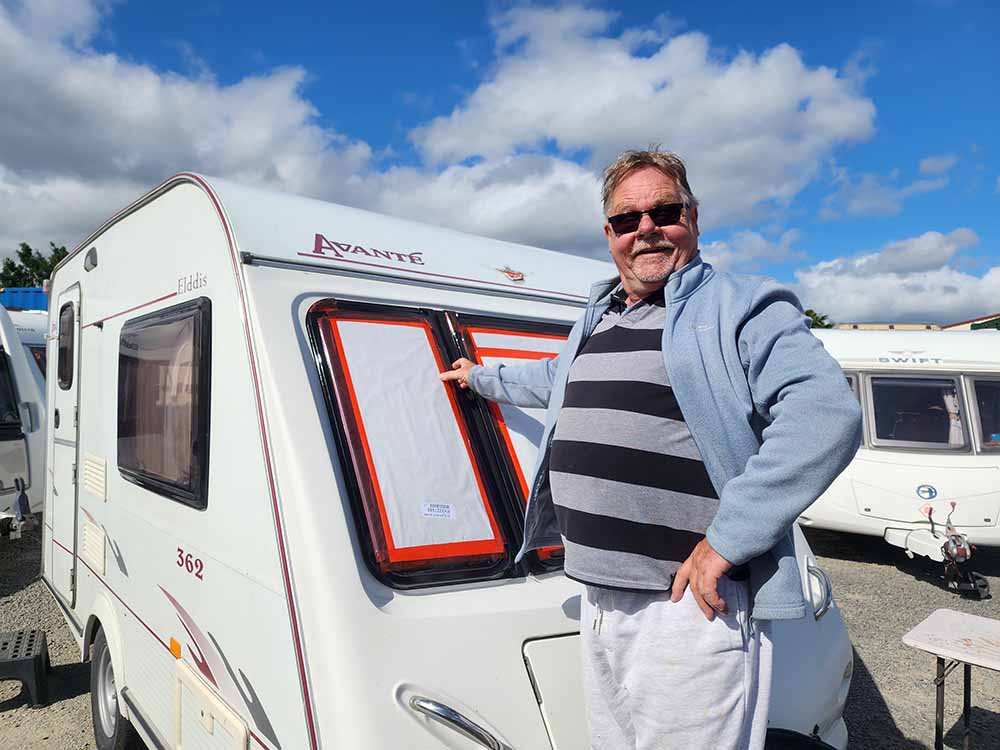 Bob from Smile Caravans installing a new window on caravan on sunny Hawkes Bay day